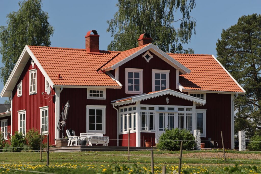 Charming Swedish house with orange roof in a lush green setting, Jönköping, Sweden.